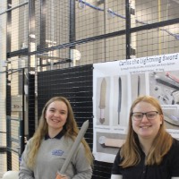Two students holding a short sword.